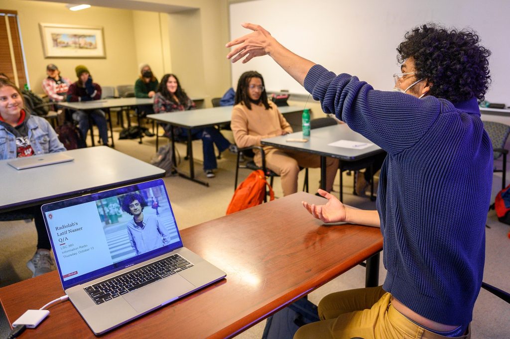 Latif Nasser, Science Journalist in Residence, gestures while answering student questions about how to communicate about science questions that have changing answers, in the Information Radio class, Life Sciences Communication 360, in Hiram Hall at the University of Wisconsin–Madison on Oct. 12, 2022. Nasser’s response was, “Lead with the question then be like, ‘There are all these people going to these absurd lengths to try to answer this question. This is the best they’ve come up with. Maybe this is true. This is as far as we can tell what’s true. And maybe it’s going to change tomorrow. Being honest with you, it’s probably going to change tomorrow. But this is the best we’ve got.’ To me, that’s a much more honest and faithful to science way to do it. And it feels for people reading it like they’re not being jerked around.” Latif Nasser is the co-host of New York Public Radio’s Peabody Award-winning Radiolab and the host and executive producer of the science documentary Netflix series Connected.
